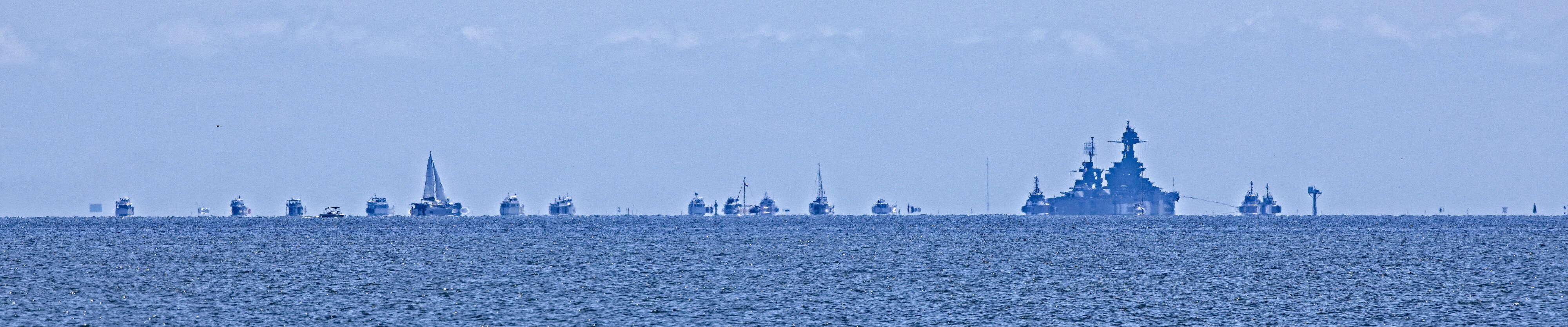 USS TEXAS BB-35 approaching Redfish Island trailed by escorting yachts Galveston Bay